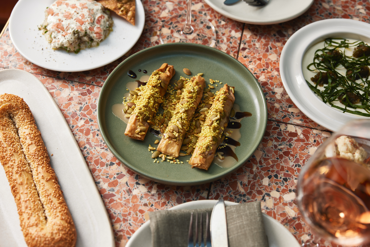 Chicken shawarma skewer with tahini, pickled cabbage, and fresh herbs on a rustic plate – Middle Eastern dining at Shaffa.