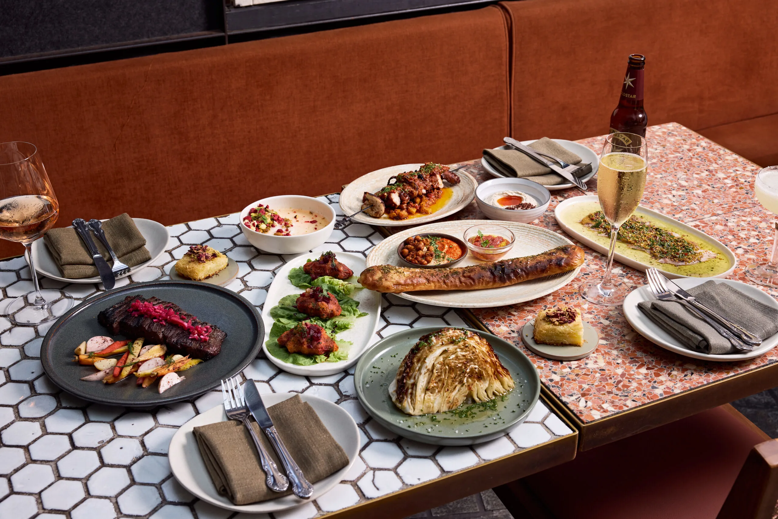 A vibrant Middle Eastern feast at Shaffa, featuring oysters, mezze, and fresh cocktails, served on a green-tiled table in Surry Hills.